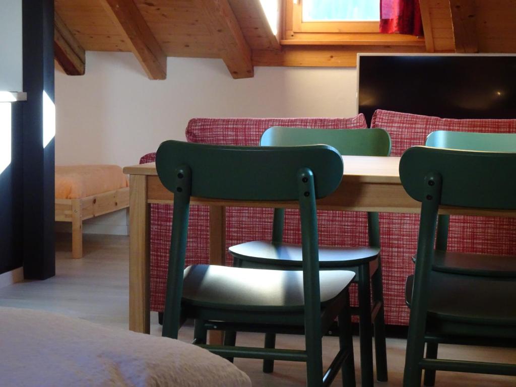 B&B Chasa Arfusch في Ardez: غرفة بها كراسي وطاولة وسرير