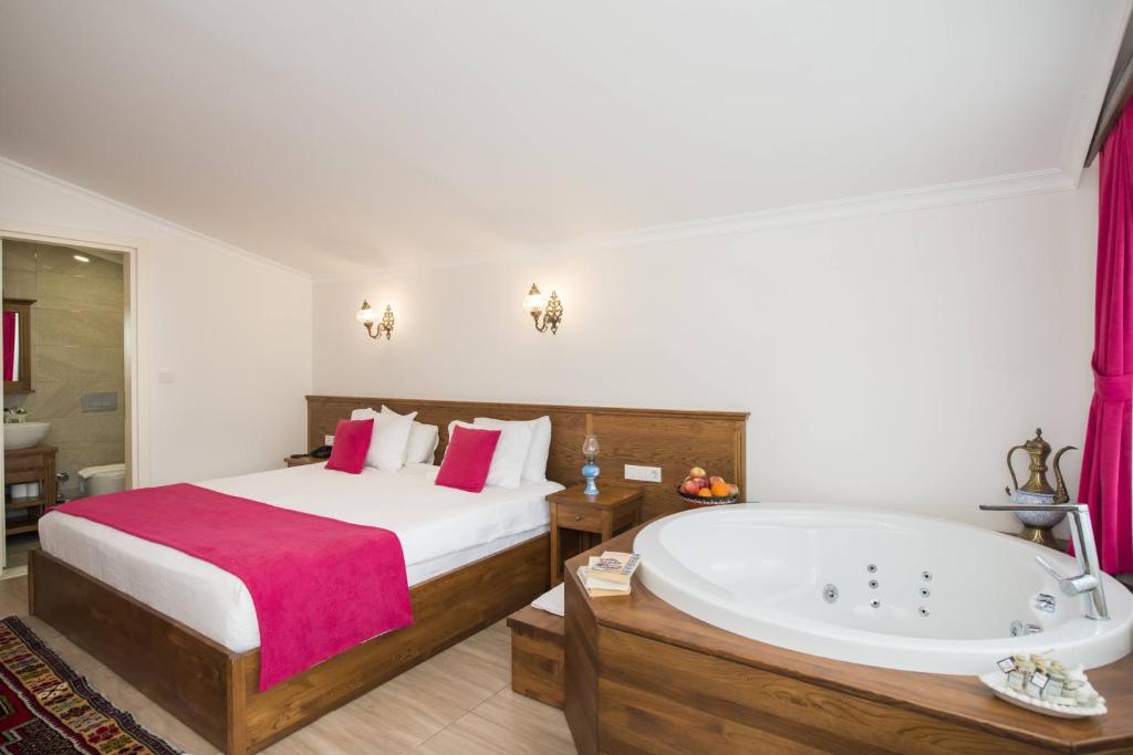 a bedroom with a bed and a bath tub at Infinity City Hotel in Fethiye