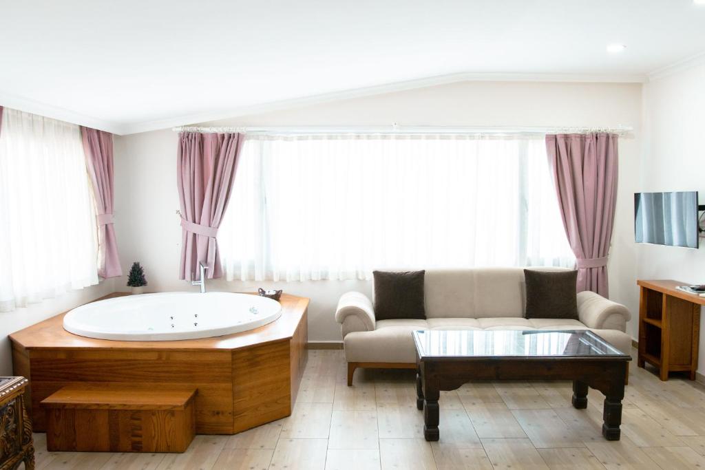 a living room with a tub and a couch at Infinity City Hotel in Fethiye