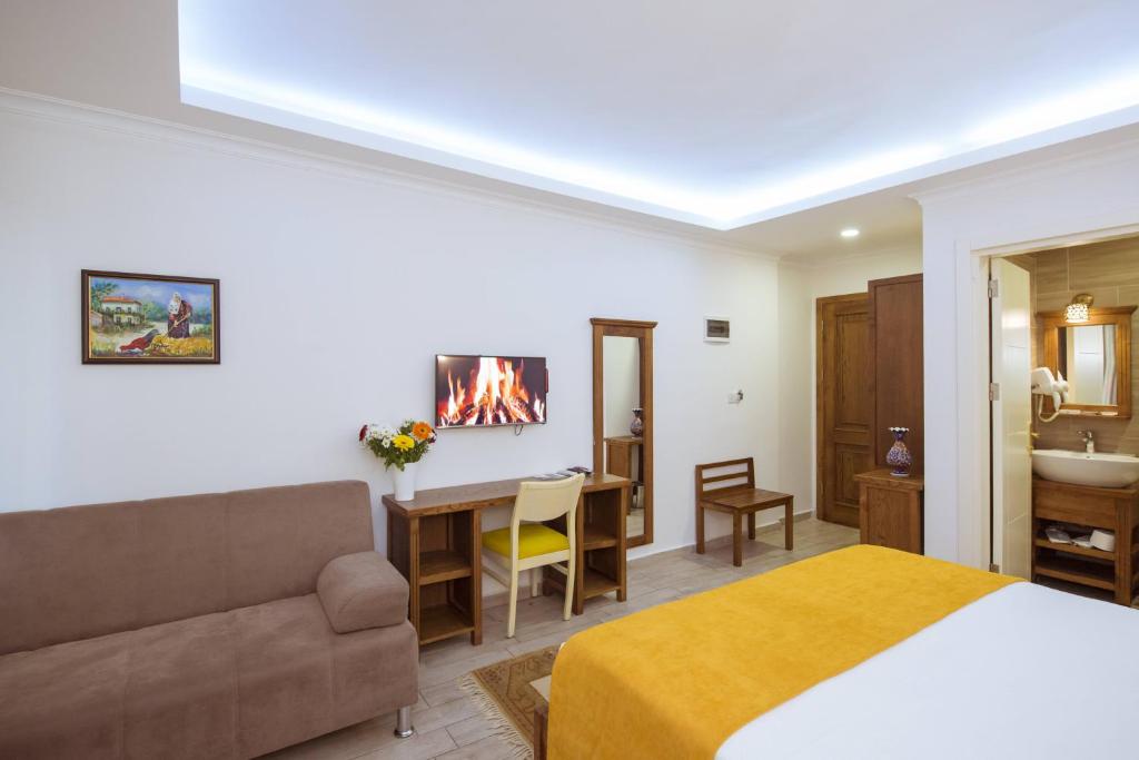a bedroom with a bed and a living room with a fireplace at Infinity City Hotel in Fethiye
