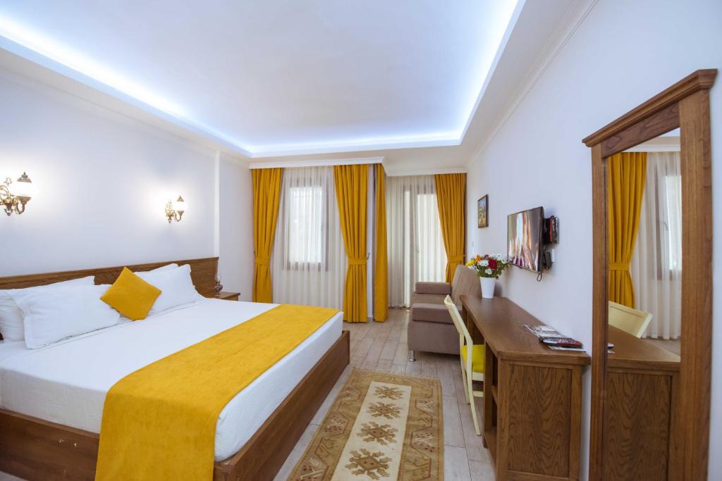 a hotel room with a bed and a desk at Infinity City Hotel in Fethiye