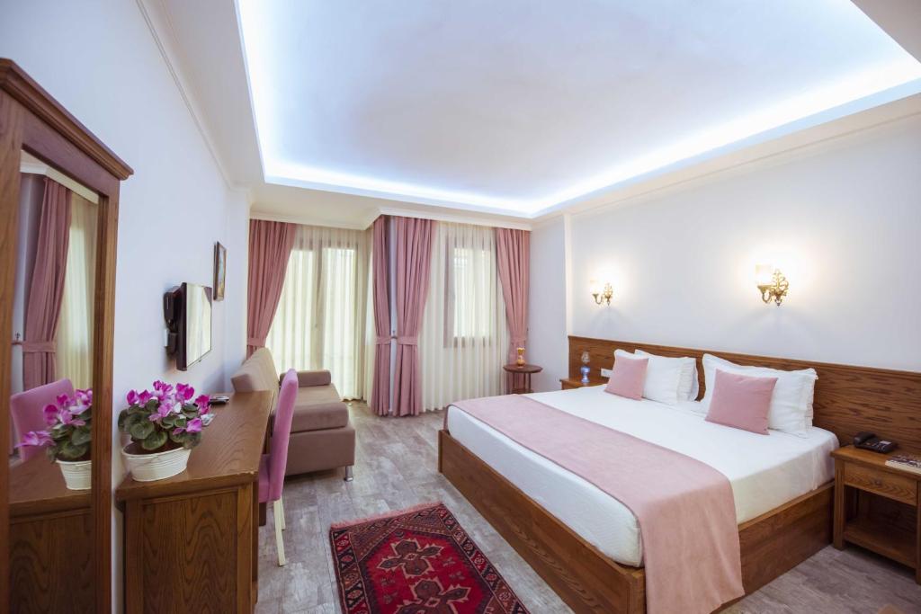 a hotel room with a bed and a couch at Infinity City Hotel in Fethiye