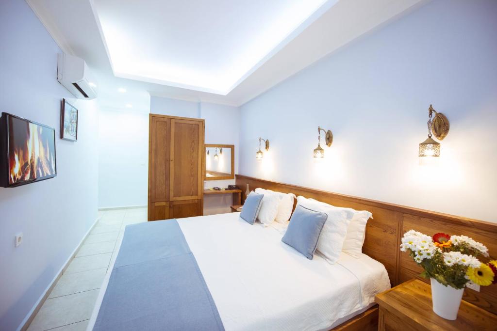 a bedroom with a white bed with flowers on it at Infinity City Hotel in Fethiye