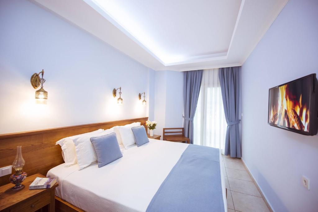a bedroom with a bed and a tv on a wall at Infinity City Hotel in Fethiye