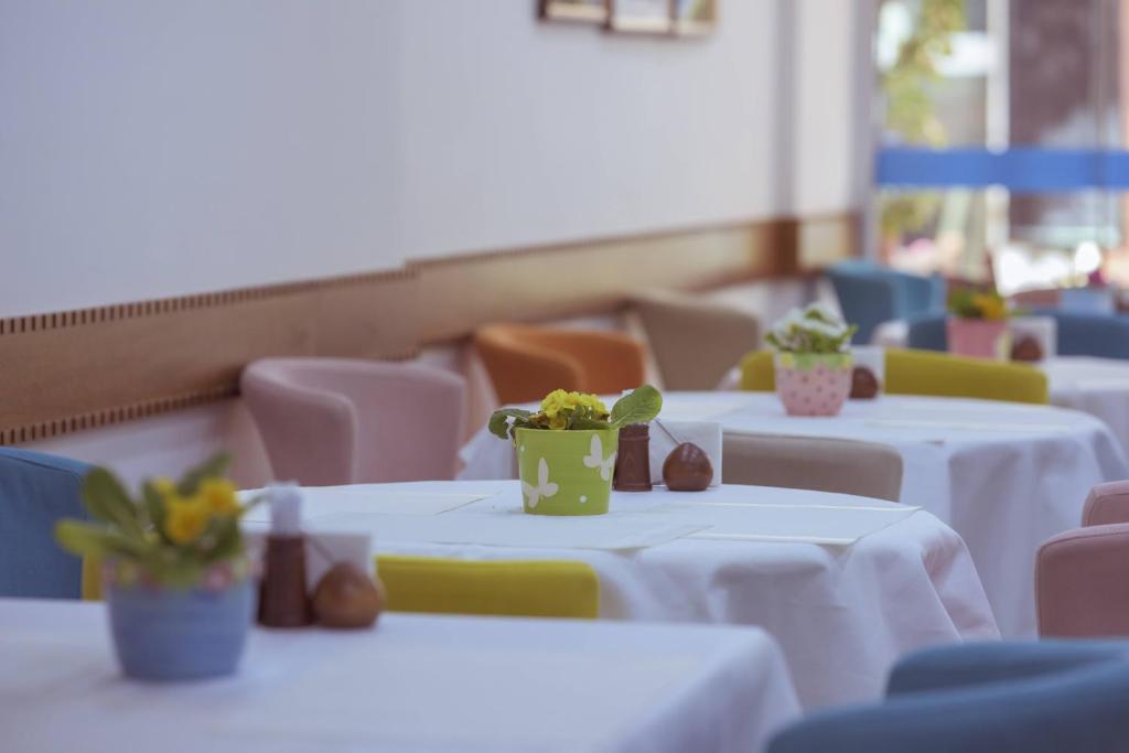 a row of tables with white table cloth and flowers on them at Infinity City Hotel in Fethiye