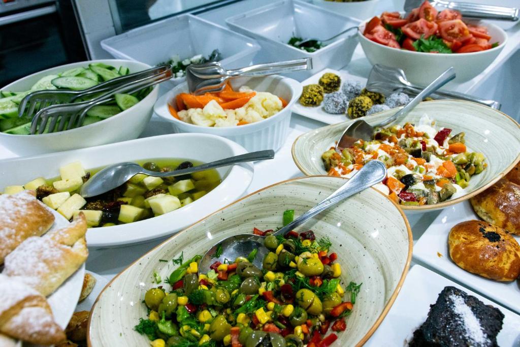 a table topped with bowls of different types of food at Infinity City Hotel in Fethiye