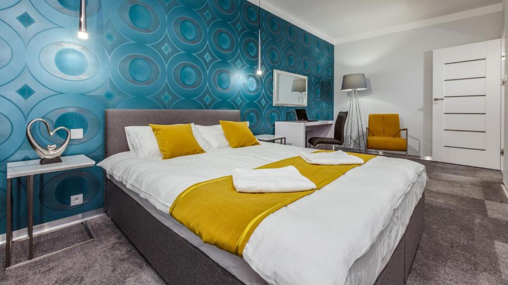 sypialnia z dużym łóżkiem z niebieską ścianą w obiekcie Apartamenty Homely Place 5 - Parking w Poznaniu