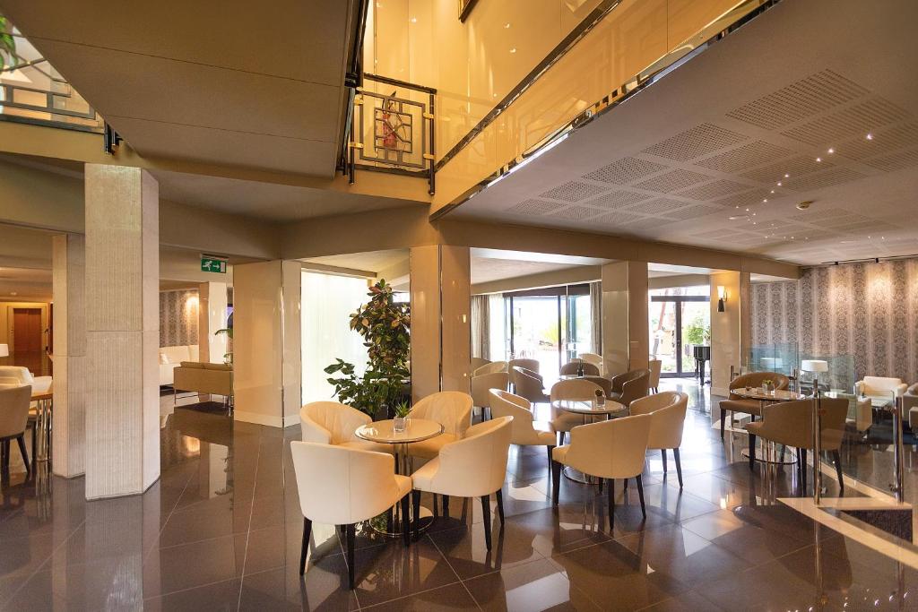 a restaurant with tables and chairs in a building at Park Hotel Imperial in Limone sul Garda