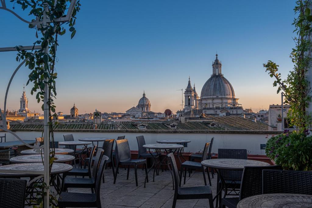 a patio with tables and chairs with a view of the city at Antica Dimora Delle Cinque Lune in Rome