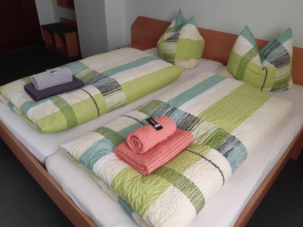 2 camas con mantas y almohadas coloridas en Pension Schöne, en Großröhrsdorf