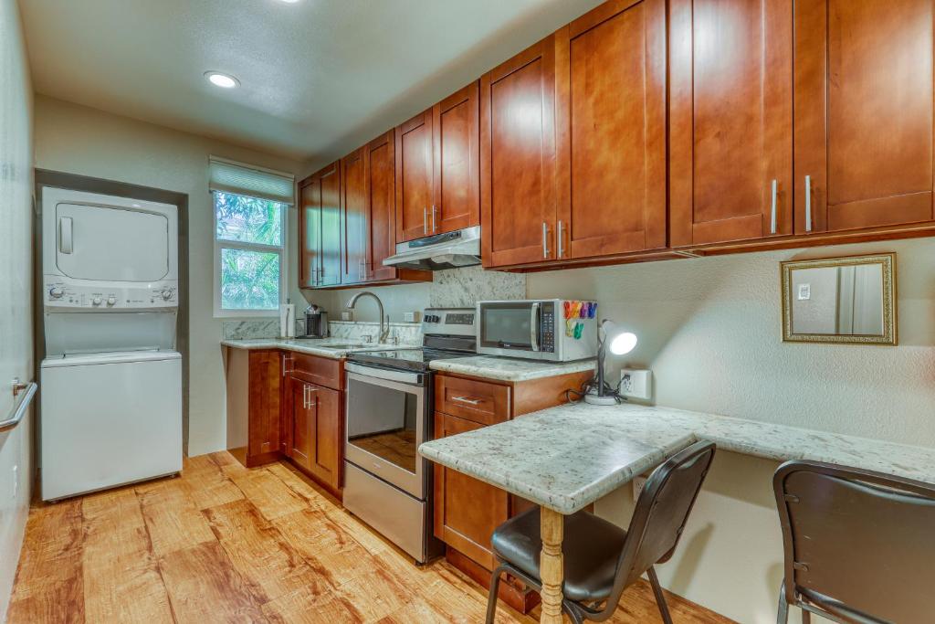 a kitchen with wooden cabinets and a white refrigerator at Monsarrat Apt. C in Honolulu