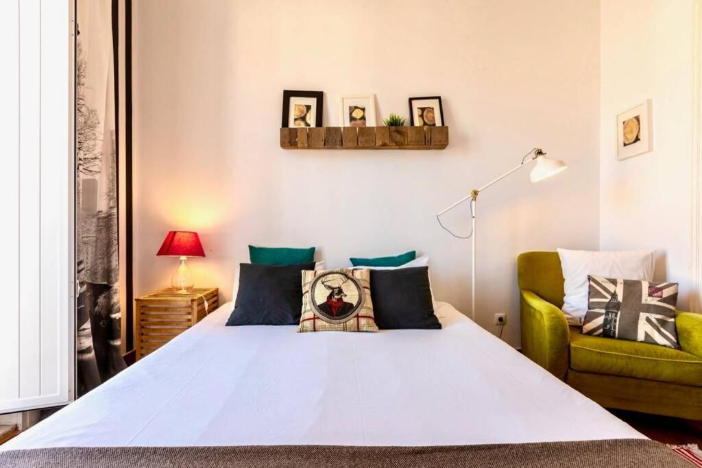 um quarto com uma cama e uma cadeira verde em Family apartment in the center - BP3 em Lisboa