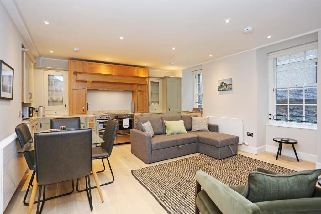 ein Wohnzimmer mit einem Sofa und einem Tisch in der Unterkunft JOIVY Modern and Airy flat on the Historic Royal Mile in Edinburgh
