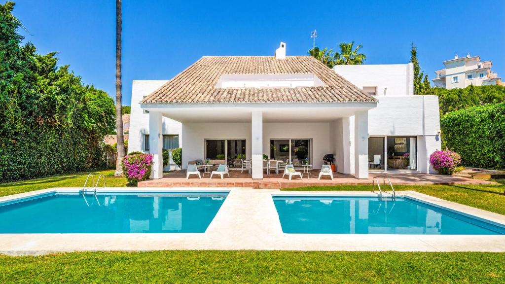 a villa with a swimming pool in front of a house at Villa Marina in Marbella