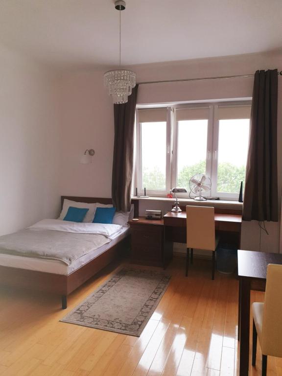 華沙的住宿－巴托茲維扎朱莉安娜拿鐵一室公寓，卧室配有一张床、一张书桌和窗户。