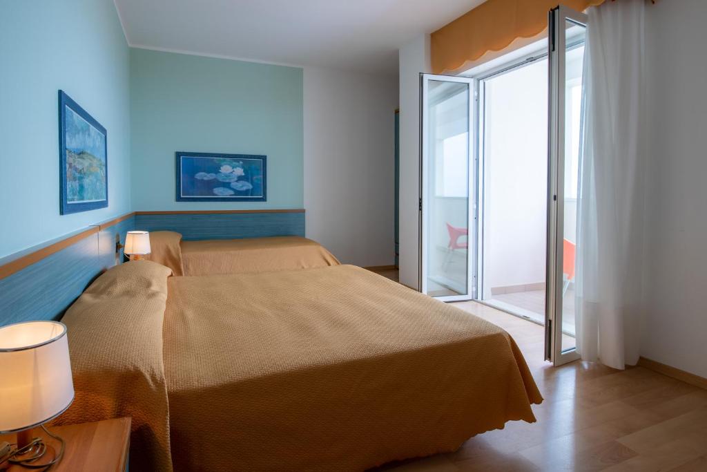 Postel nebo postele na pokoji v ubytování Hotel Parigi