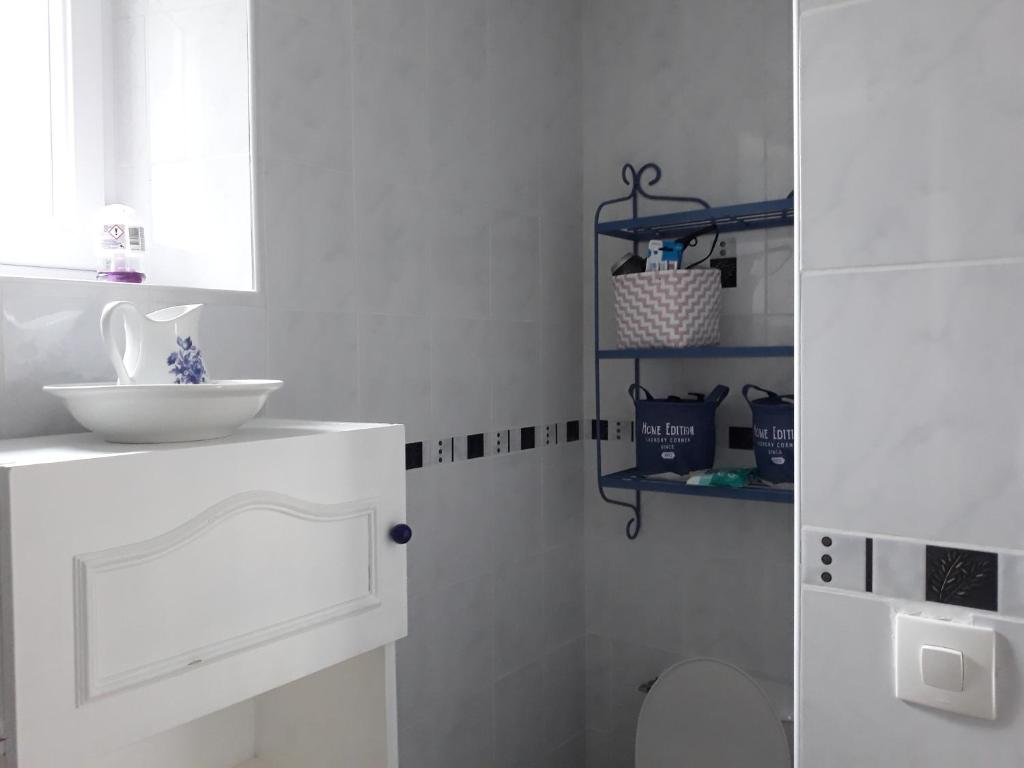 a white bathroom with a sink and a toilet at Chambres d'Hotes Elvire et Laurent Barbey in Sainte-Marie-du-Mont