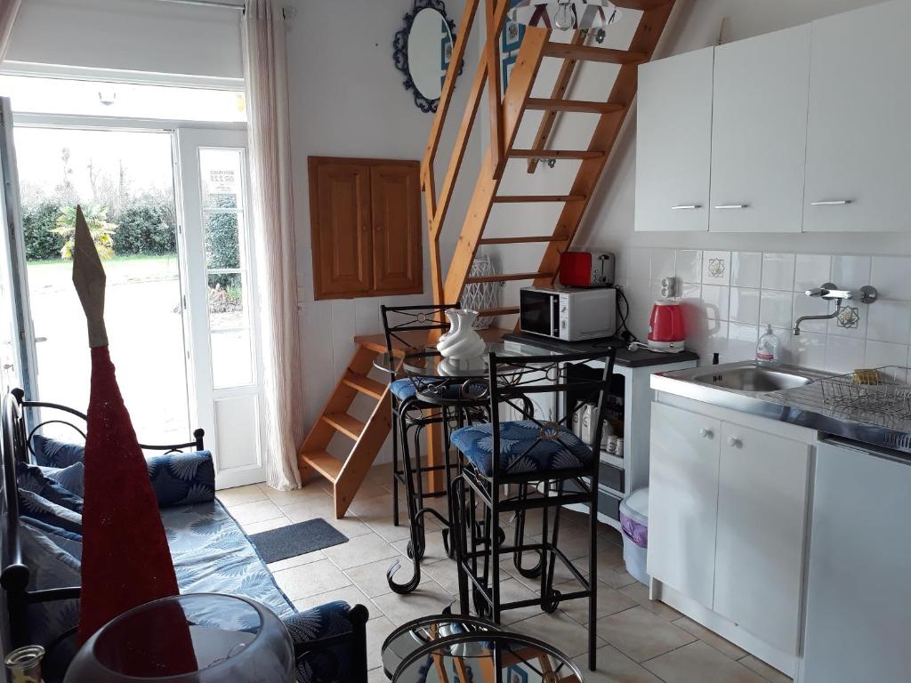 a kitchen with a staircase and a counter with stools at Chambres d'Hotes Elvire et Laurent Barbey in Sainte-Marie-du-Mont