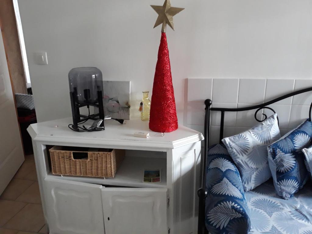 a red hat on top of a white table next to a bed at Chambres d'Hotes Elvire et Laurent Barbey in Sainte-Marie-du-Mont