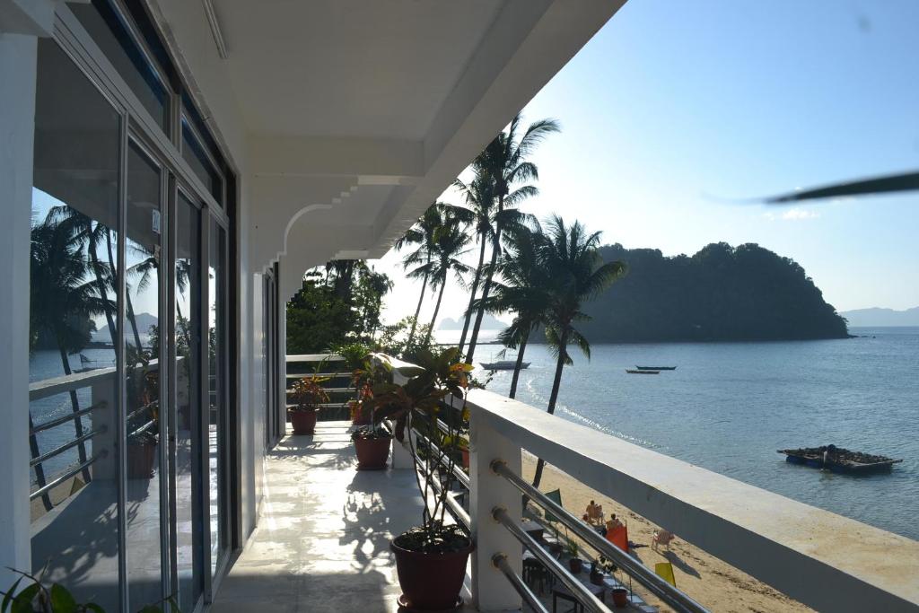 a balcony of a house with a view of the ocean at Orange Pearl Beach Resort in El Nido