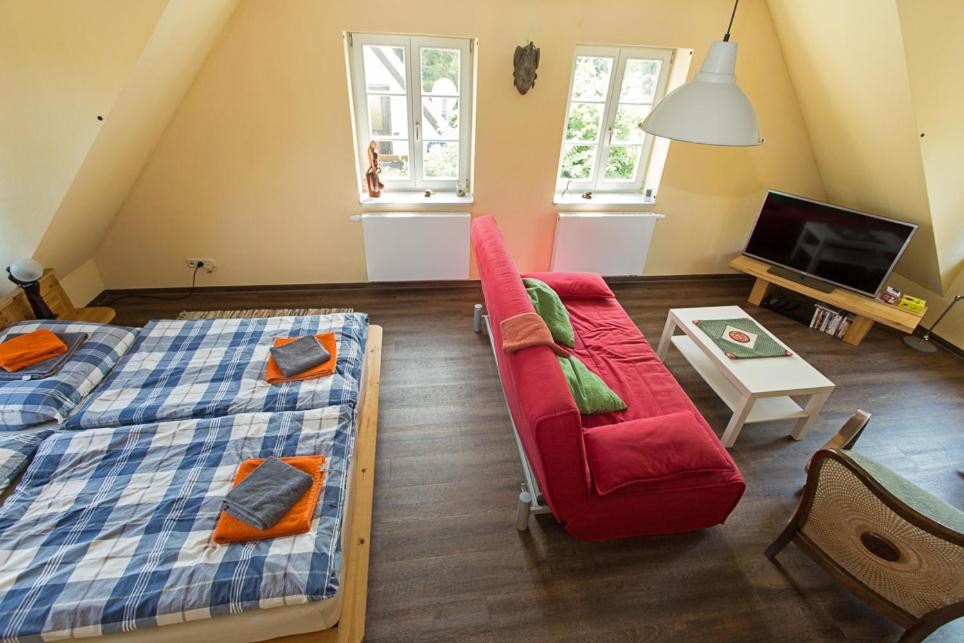 a living room with a bed and a red couch at Hügelhus in Kloster