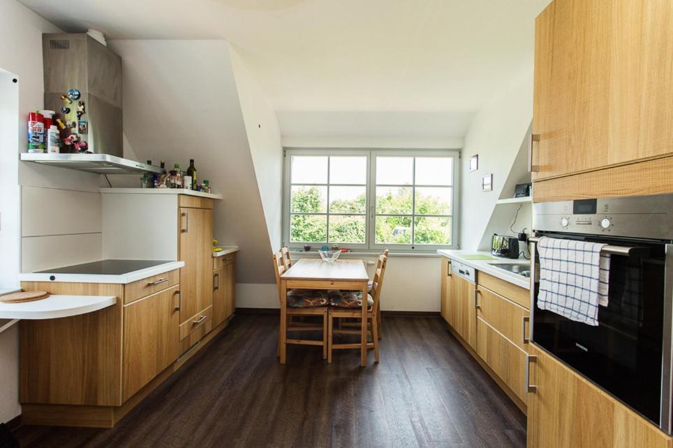 a kitchen with wooden cabinets and a table and a window at Hügelhus in Kloster