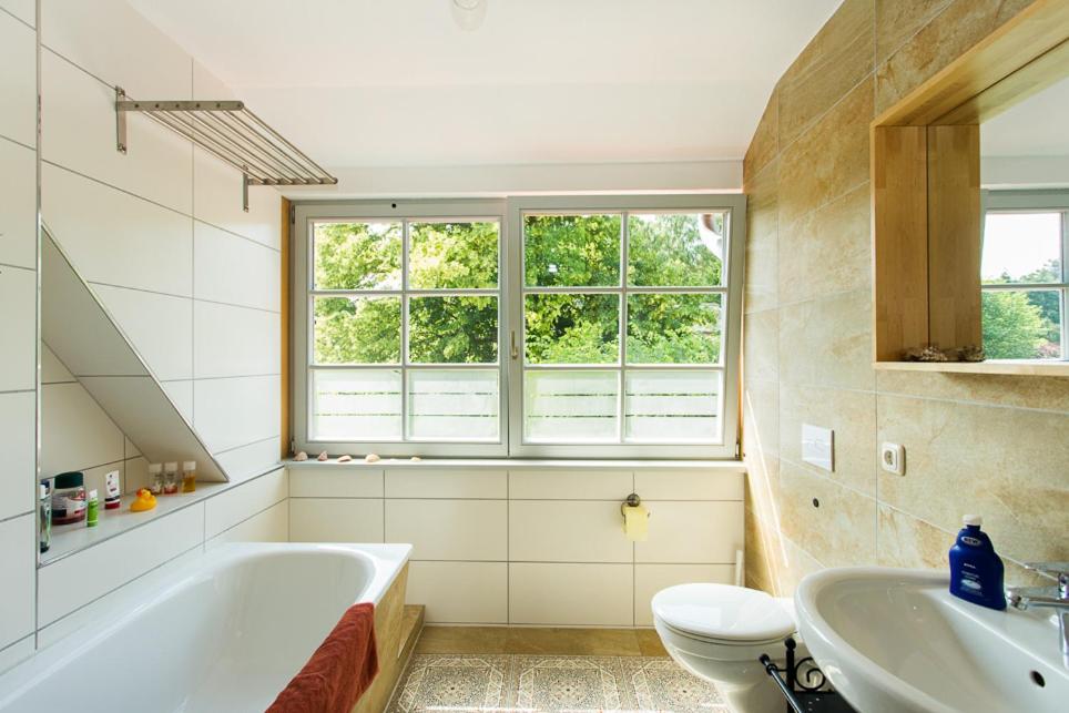 a bathroom with a tub and a toilet and a sink at Hügelhus in Kloster
