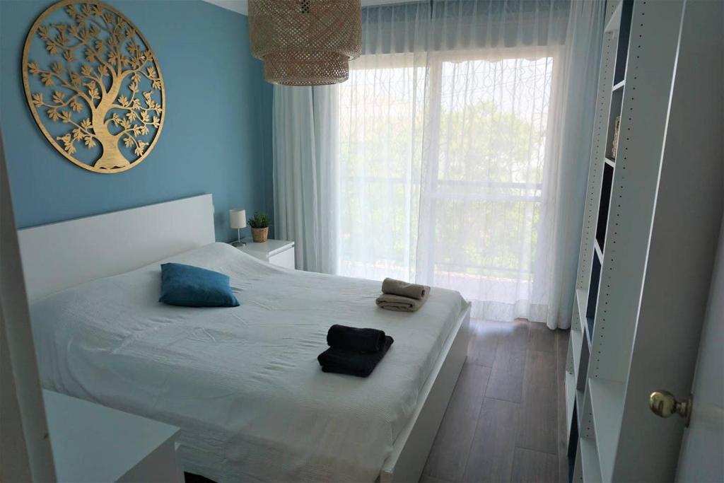 a bedroom with a bed with blue walls and a window at CASA LUCA in Estepona