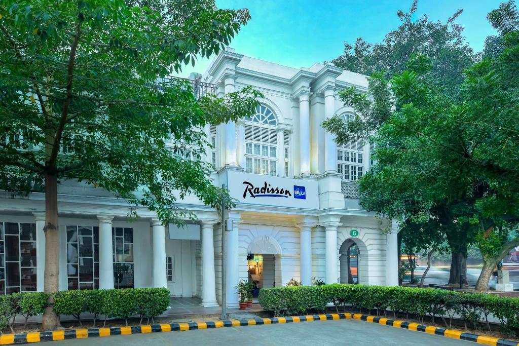 een wit gebouw met een bord erop bij Radisson Blu Marina Hotel Connaught Place in New Delhi