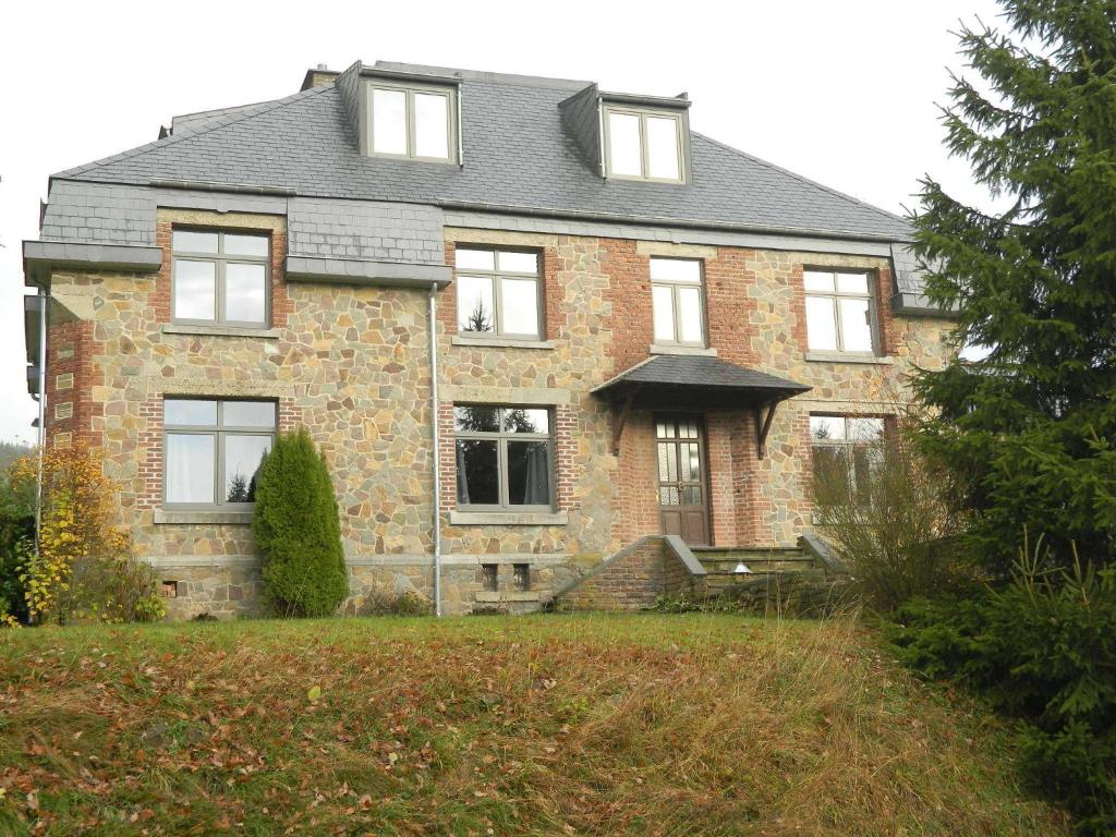 a large brick house with a gray roof at B&B Les Tchéous in La Gleize