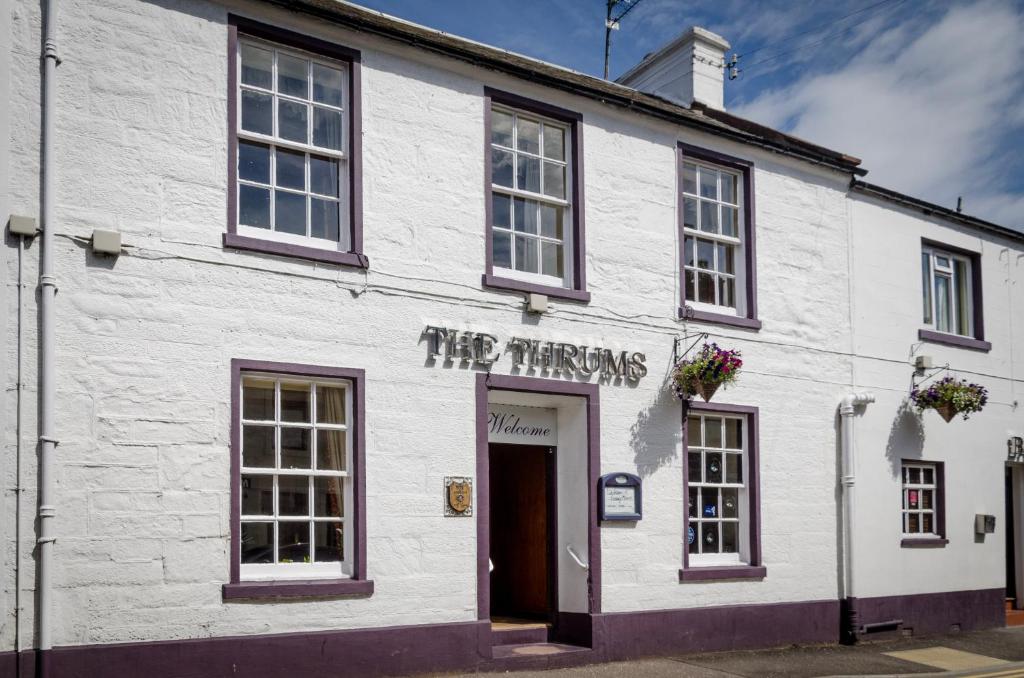 a white building with a sign that reads the tringers at Thrums Hotel, Kirriemuir in Kirriemuir