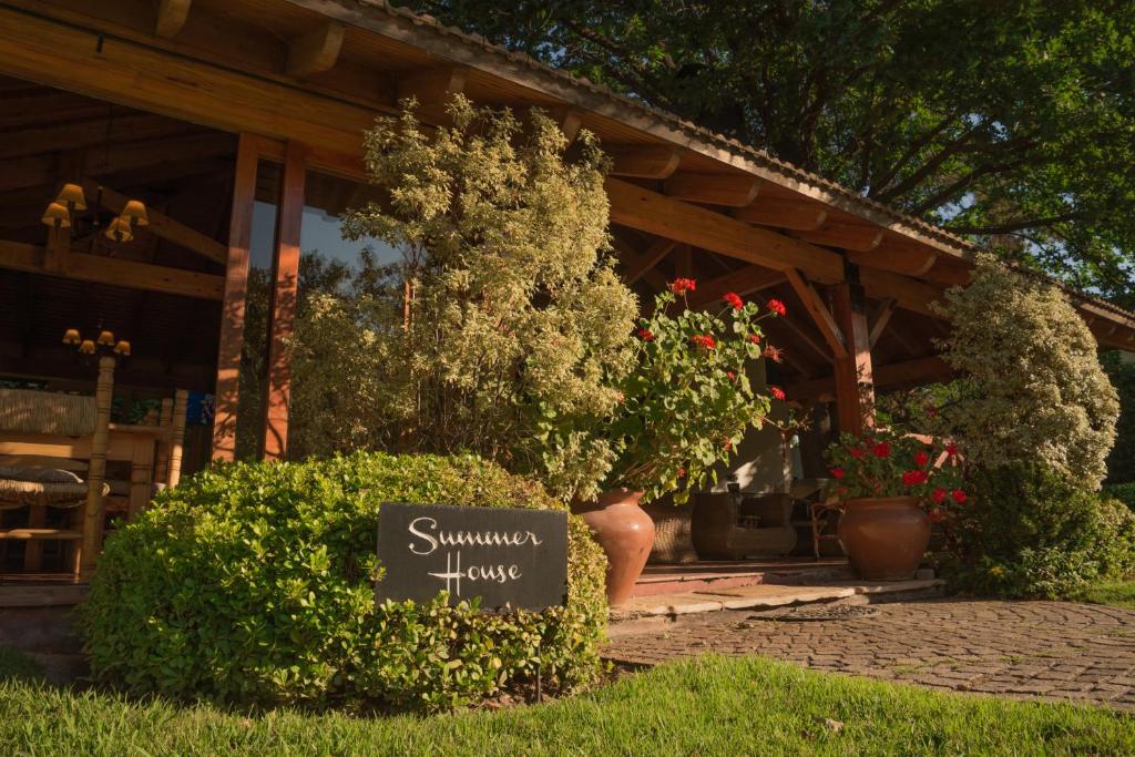 un panneau dans l'herbe devant une maison dans l'établissement Casa de Coria, à Chacras de Coria