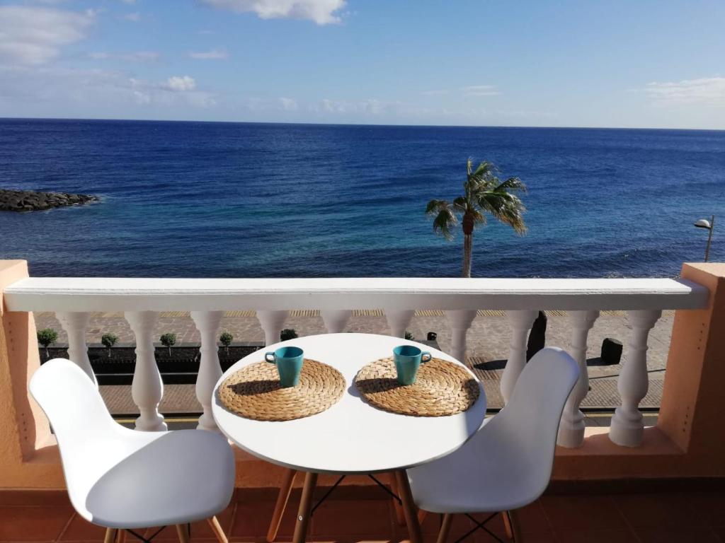 een tafel en stoelen met uitzicht op de oceaan bij Blue relax Candelaria in Candelaria