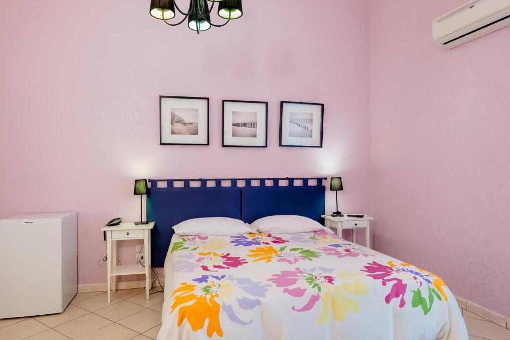 1 dormitorio con 1 cama con colcha de flores en BB Augusteo, en Nápoles