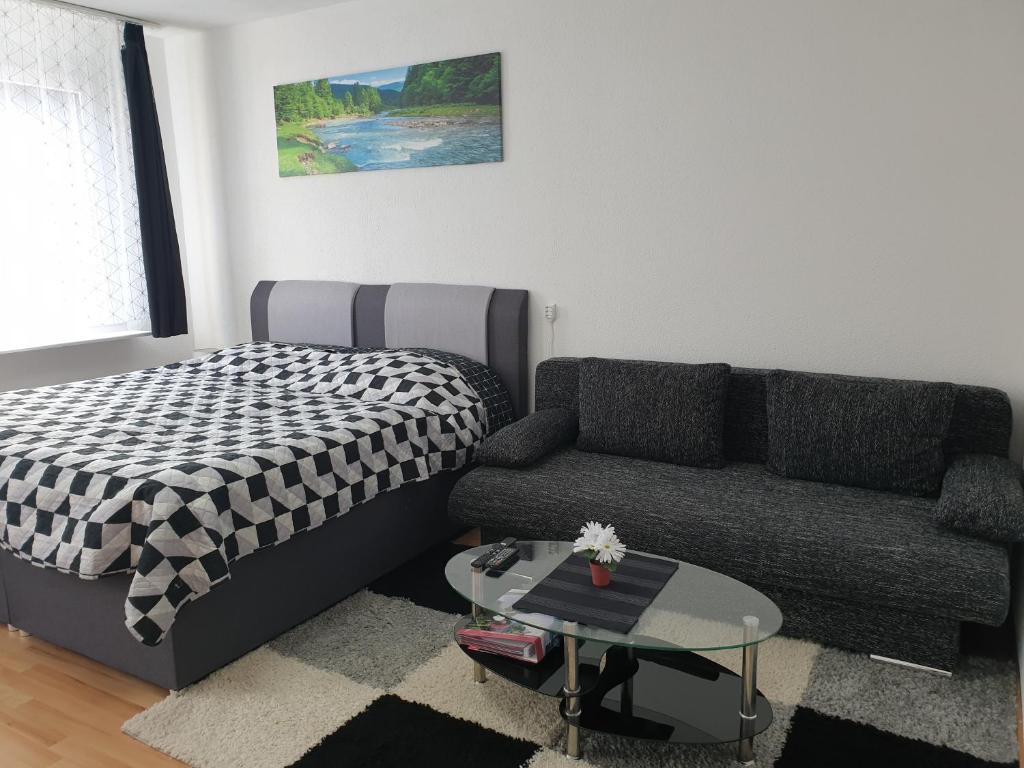 uma sala de estar com uma cama e um sofá em KM Apartment em Triberg