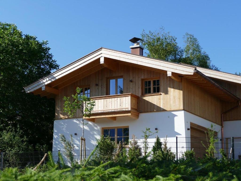 una casa con balcón en la parte superior en Bodenschneid Suiten Neureuthblick, en Kreuth