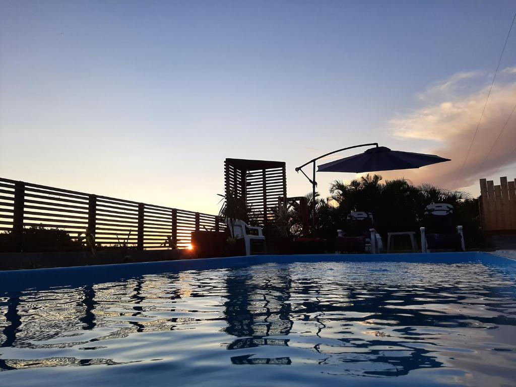 a swimming pool with the sunset in the background at La kazanou in Saint-Joseph