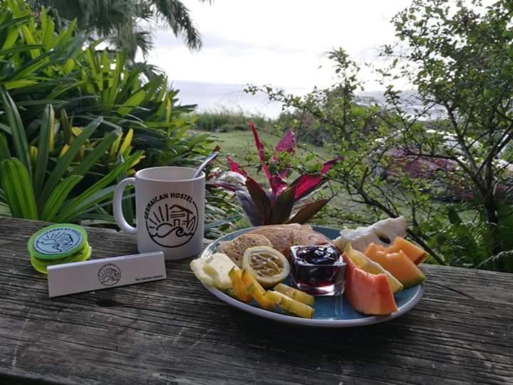 un plato de comida en una mesa con una taza de café en Germaican Hostel en Port Antonio