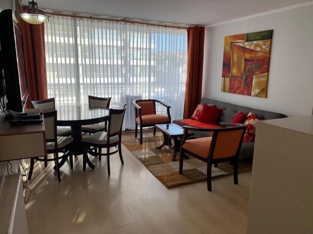 a living room with a table and chairs and a couch at Departamento en el corazón de Viña del Mar in Viña del Mar