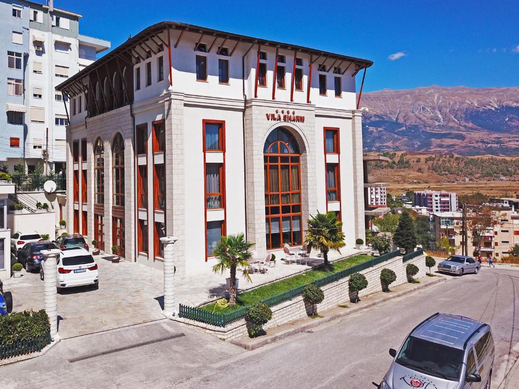 a large building with a clock on the top of it at Hotel Vila Sharm in Gjirokastër