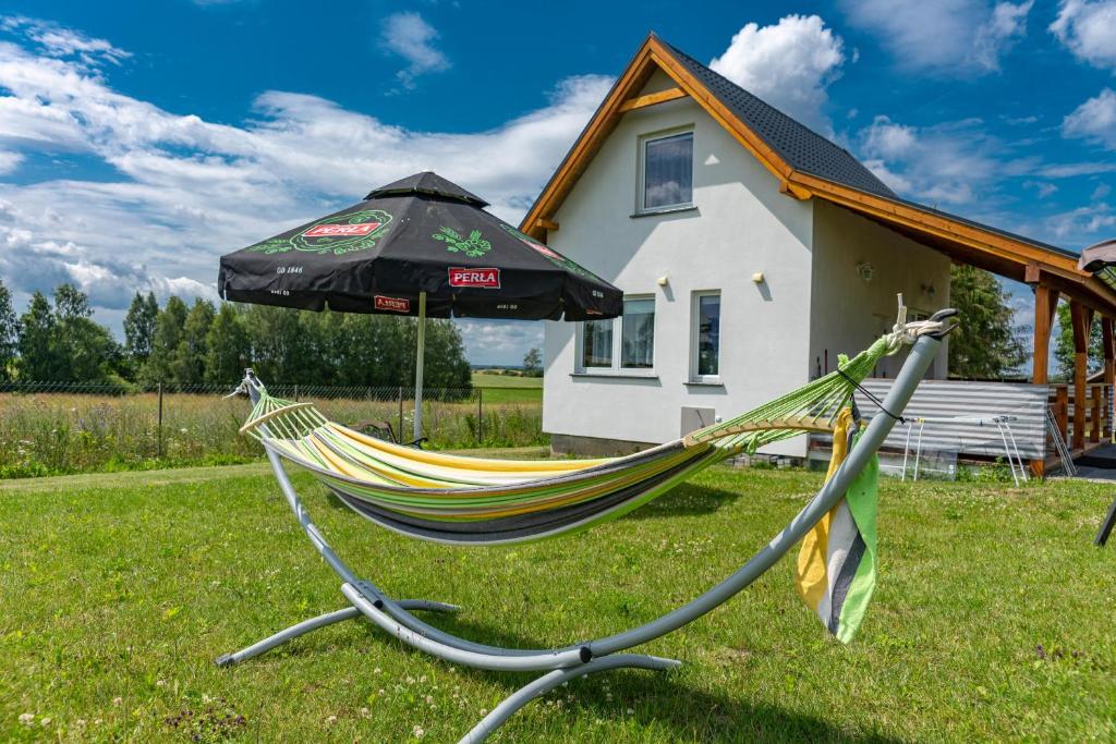 a hammock and an umbrella in a yard at Domek VICTORIA in Giżycko