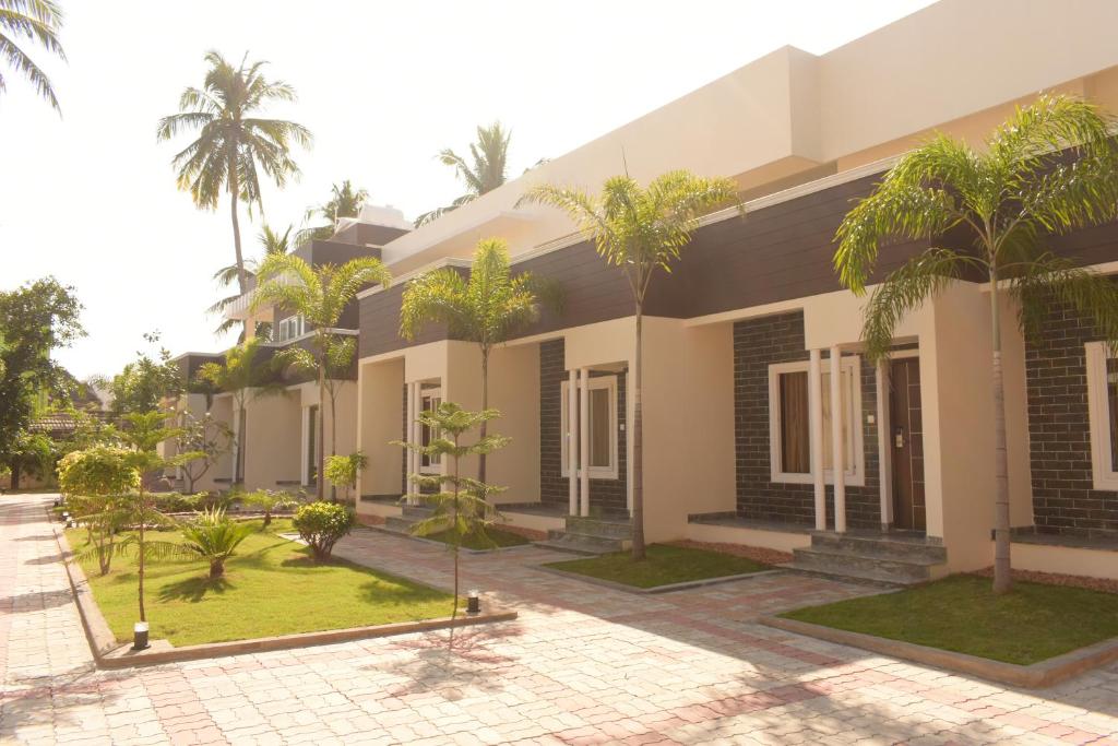 une maison avec des palmiers devant elle dans l'établissement Tranquil Park, à Pondichéry