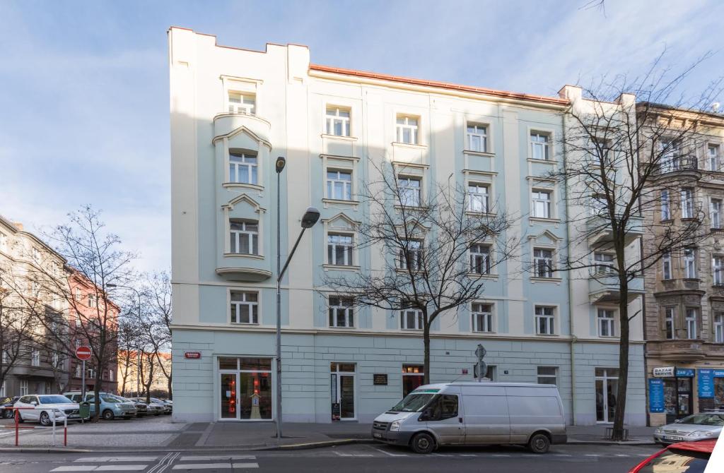 un edificio bianco con un furgone parcheggiato di fronte di Lampi Hotel Prague a Praga