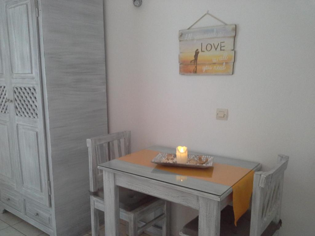 a table and chairs in a room with a candle at Kiklamino Sunset Studios in Oia