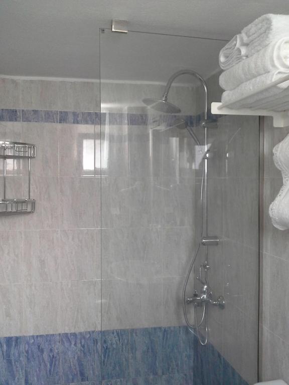 a shower in a bathroom with a glass door at Kiklamino Sunset Studios in Oia