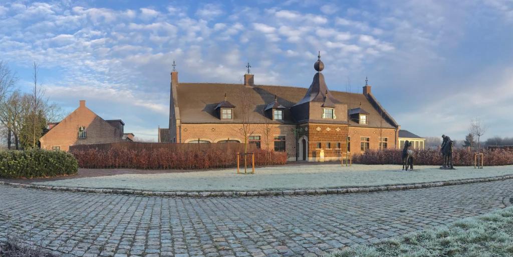 a large house with a cobblestone street in front of it at Ask Lily in Westmeerbeek