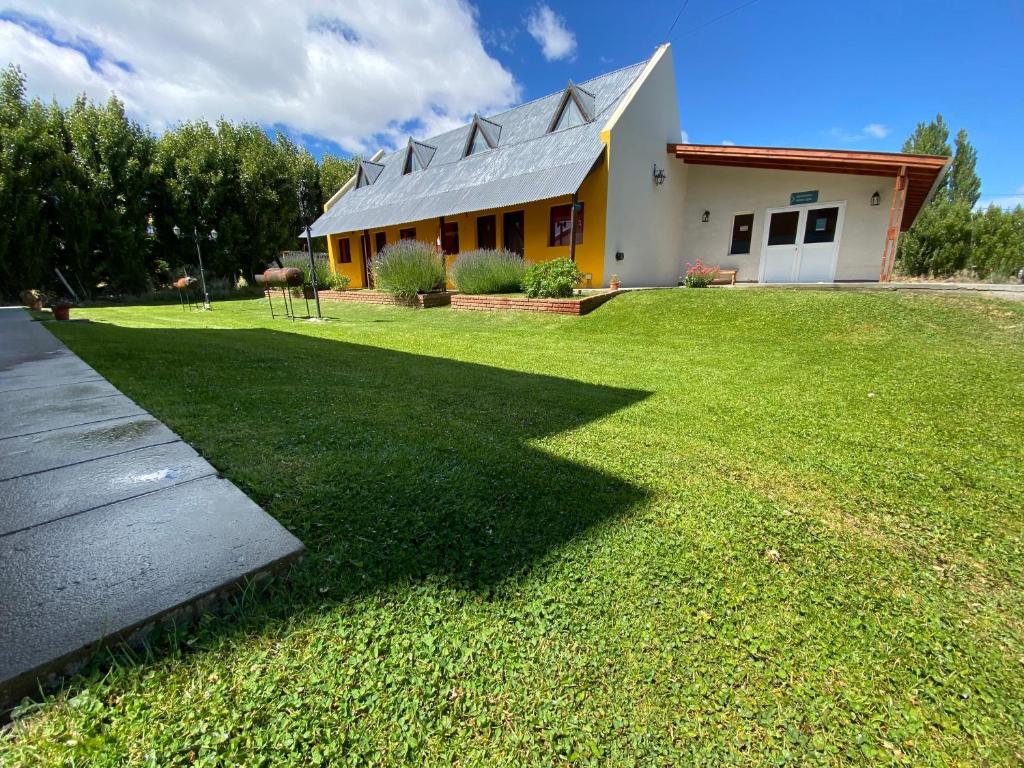 una casa con un gran césped delante de ella en Hotel y Cabañas Las Marías en El Calafate