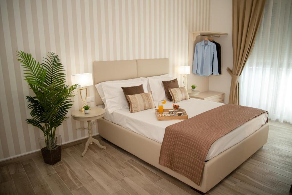 a bedroom with a large white bed with a table at Porta Aragonese Luxury Rooms in Palermo