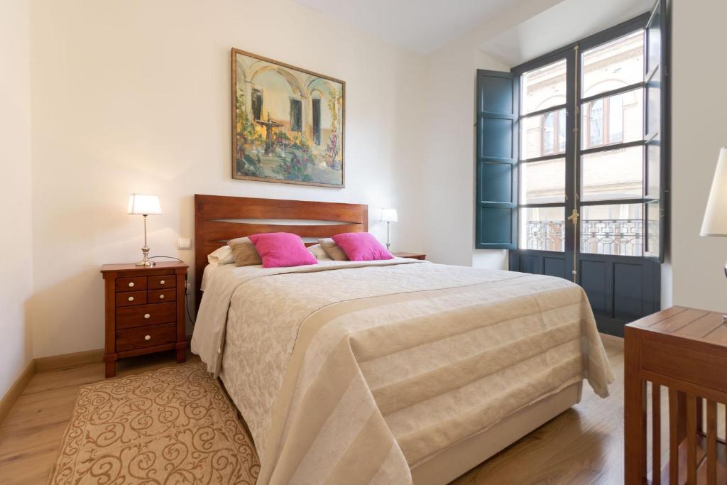 セビリアにあるEscapada Romántica, 2 pax, Centro Históricoのベッドルーム1室(ピンクの枕が付いた大型ベッド1台付)