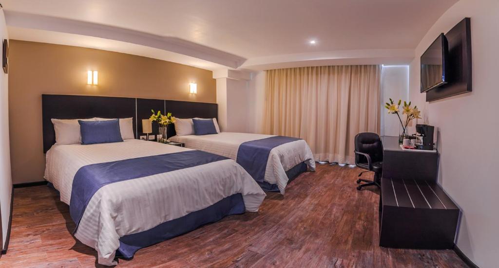 een hotelkamer met 2 bedden en een televisie bij Hotel Zenith in Tehuacán